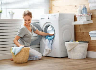 洗濯機に洗濯物を入れる女性