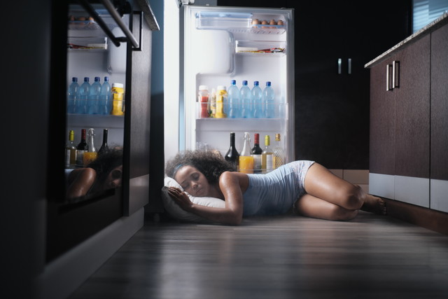 冷蔵庫を開けたまま寝ている女性