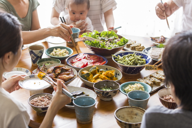 食卓を囲んで食事する家族