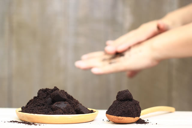 Woman hand with scrub coffee grounds on wooden background, Beauty and healthy care concept