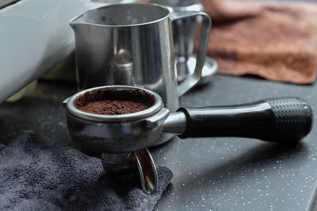 Marble Desktop. Coffee machine handle with coffee residue. Stainless steel milk cylinder. Different cleaning cloth