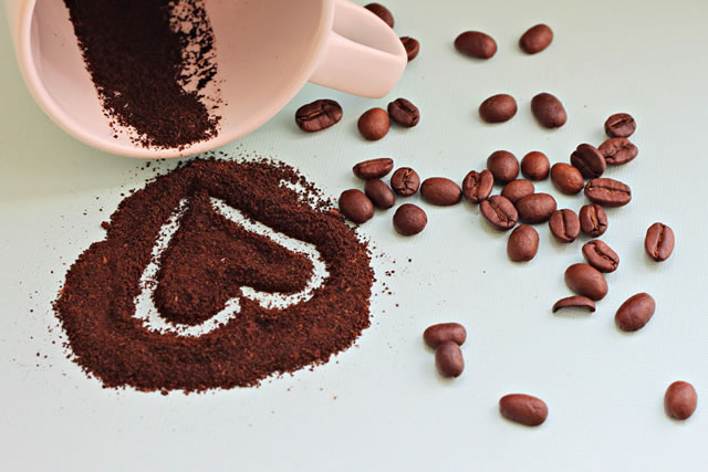 heart drawn on coffee grounds and beans scattered cup