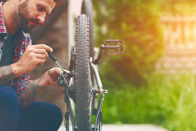 man repairing bike with screwdriver