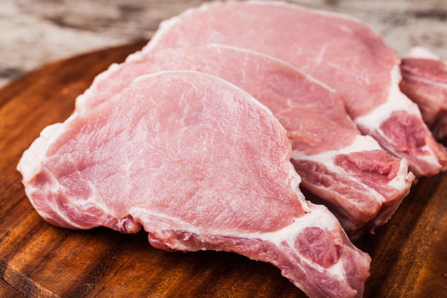 木製まな板の上の生の豚肉