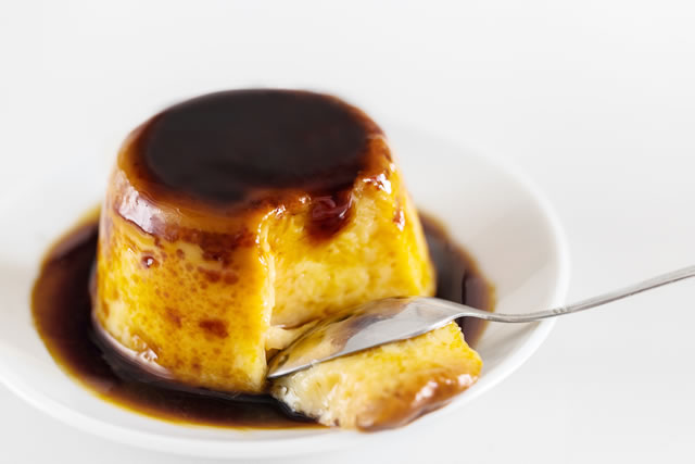 Creme caramel dessert or flan on white table. Delicious pudding served with liquid caramel