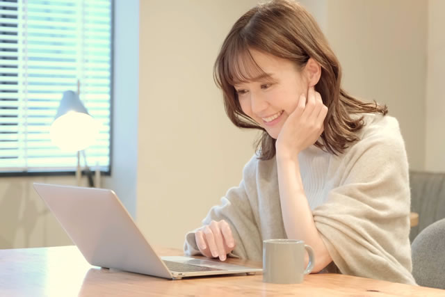 パソコンでブログを読んでいる女性