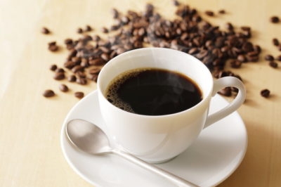 白いコーヒーカップのホットコーヒーとコーヒー豆