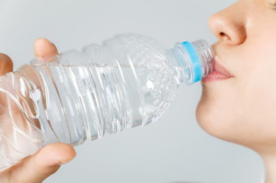 ペットボトルで水を飲む女性