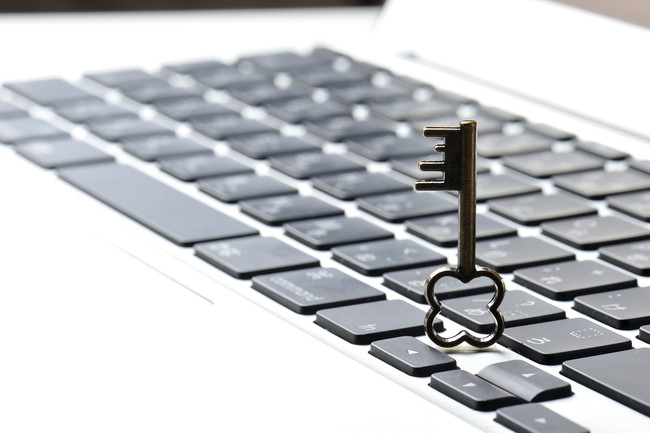 パソコンのキーボードと小さな鍵の写真,個人情報保護のイメージ写真