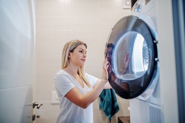 洗濯機で洗濯をしている女性