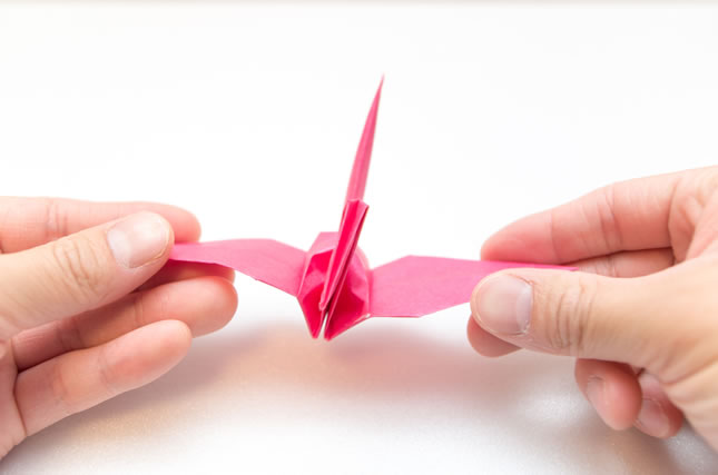 折り紙の鶴を持つ手