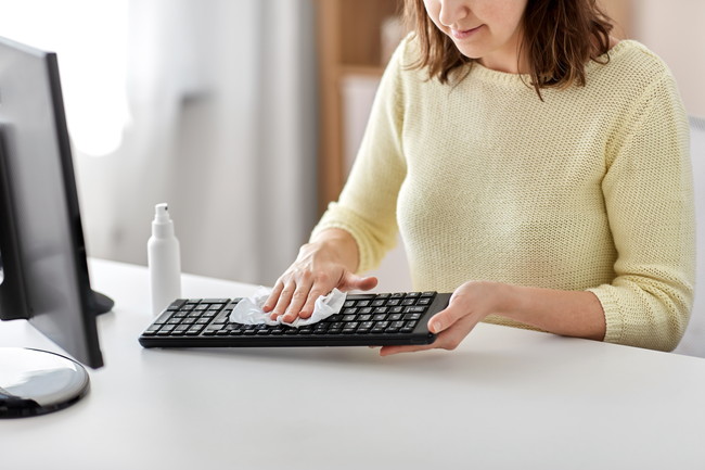 パソコンのキーボードを掃除している女性