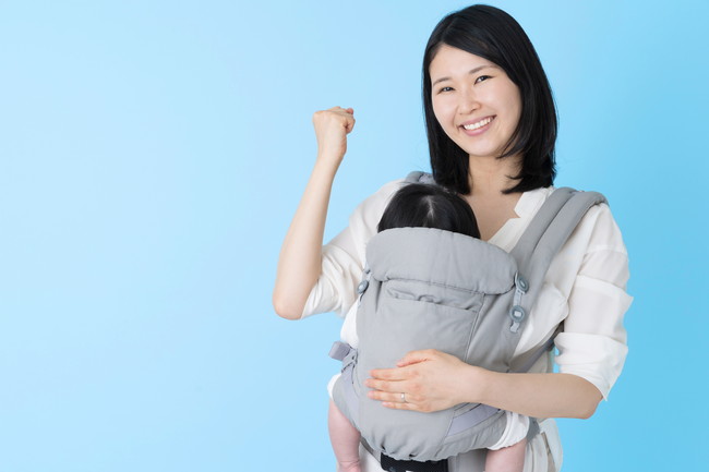 抱っこ紐で赤ちゃんを抱っこしている女性