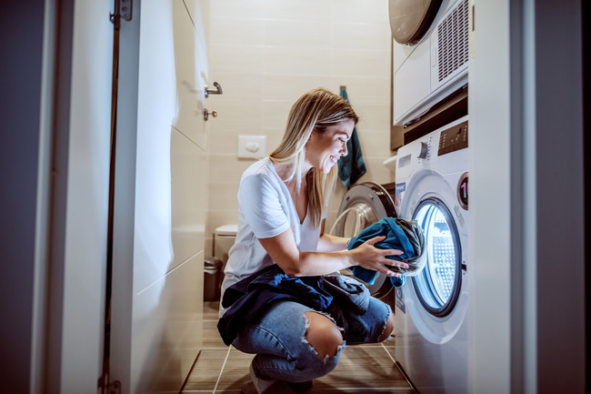 洗濯機で洗濯する女性
