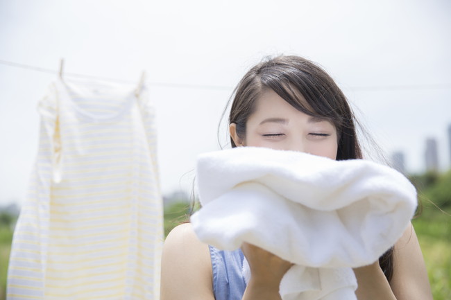 仕上がった洗濯物の香りを楽しむ女性