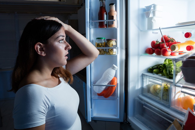 冷蔵庫の中を見ている女性