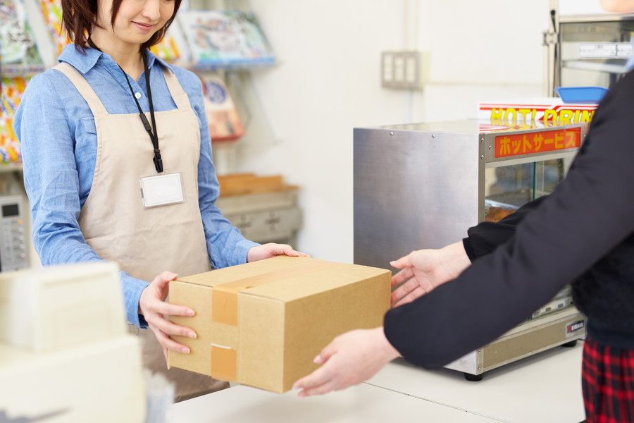 コンビニで荷物を発送する女性