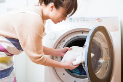 ドラム式洗濯機で洗濯している女性
