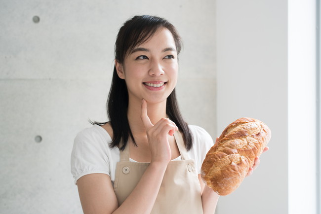 フランスパンを持つ女性