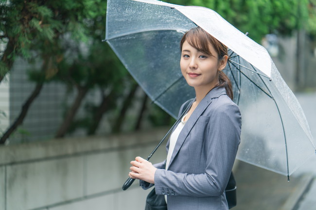 傘をさしているスーツ姿の女性