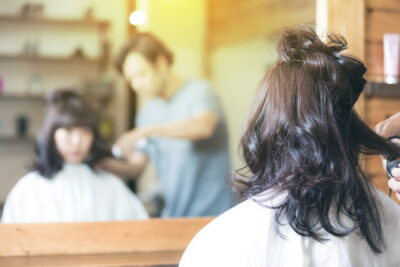 美容院で髪をカットしている女性