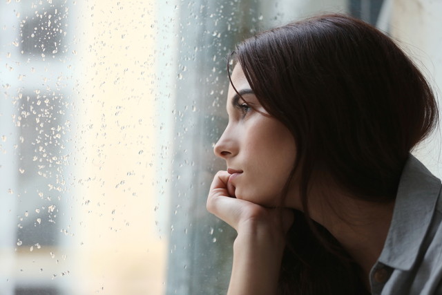 雨を見つめる女性