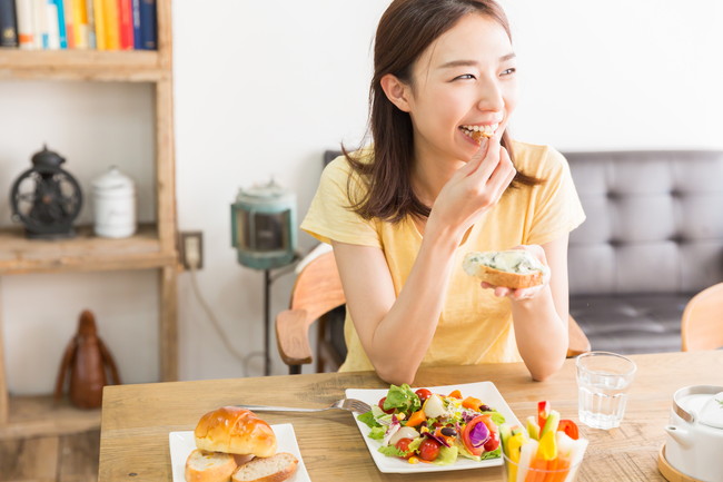 自宅でサラダを食べる女性