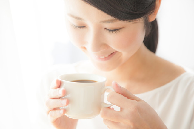 笑顔でコーヒーを飲む女性