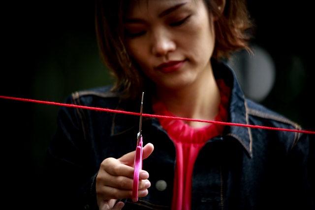 赤い糸を切る女性