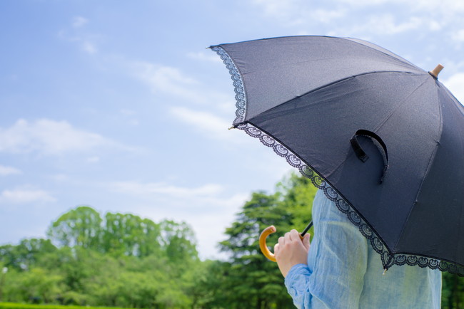 黒い日傘をさしている女性