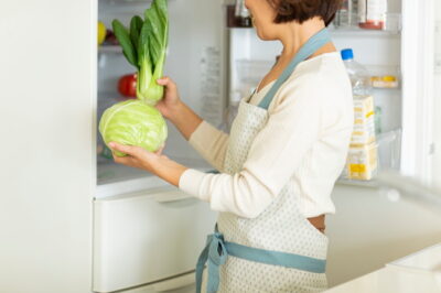 冷蔵庫から野菜を取り出す主婦
