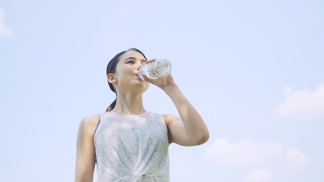 屋外で水を飲む女性