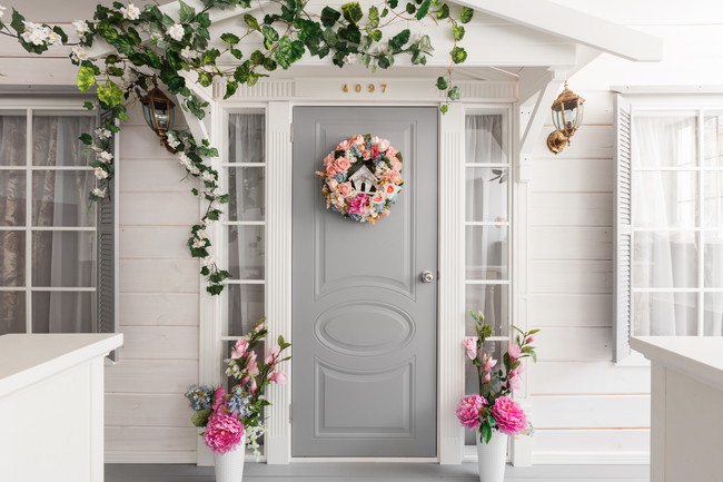 白い玄関ドアと花のリース