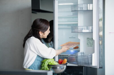 冷蔵庫に食材を入れる女性