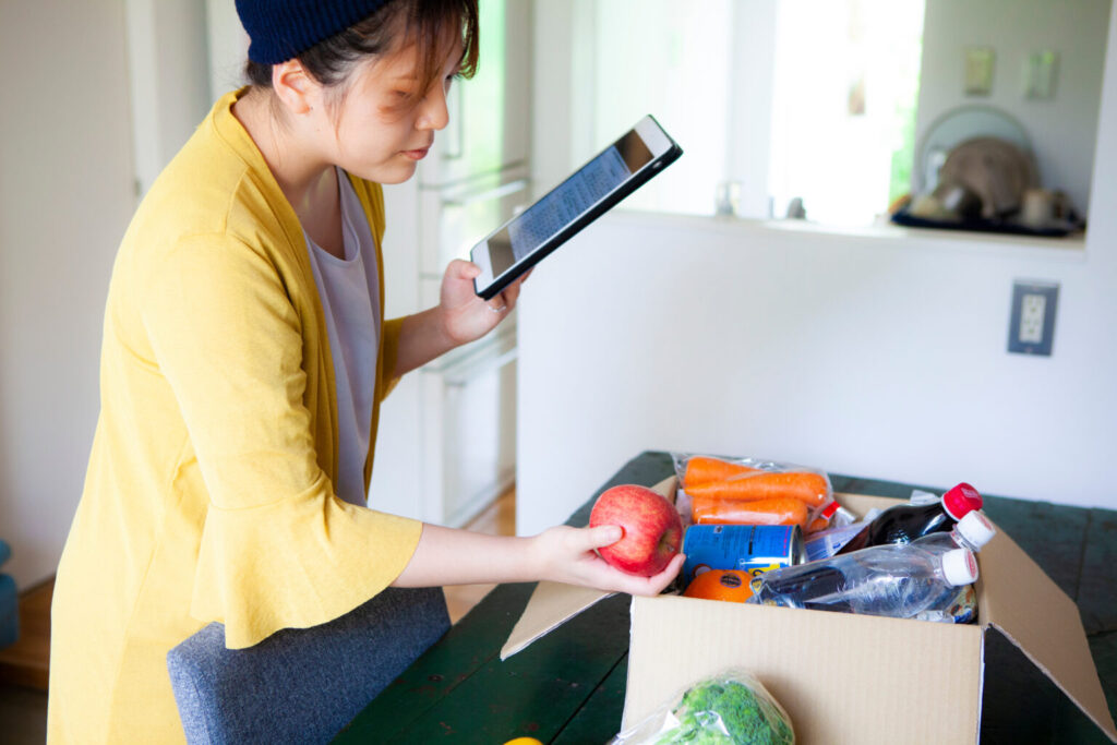 ネットスーパーで購入した食材を確認する女性