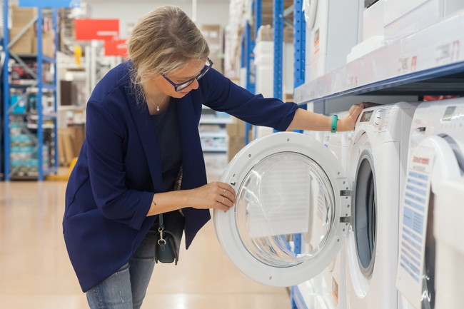 量販店でドラム式の洗濯機を見ている女性