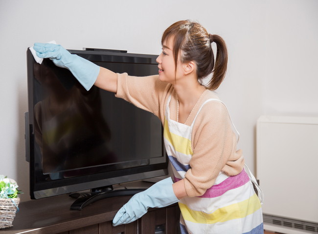 テレビを拭く女性