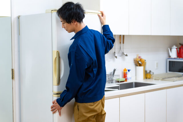 冷蔵庫を運ぶ日本人男性