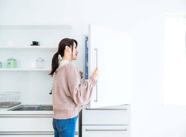 冷蔵庫の中を見る女性