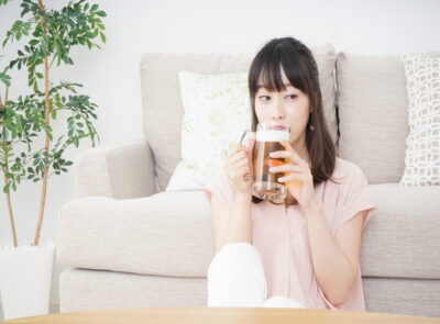 部屋でビールを飲む女性