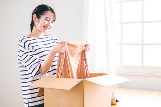 洋服を箱から出す女性