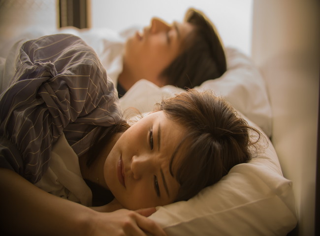 ベッドで悩む女性
