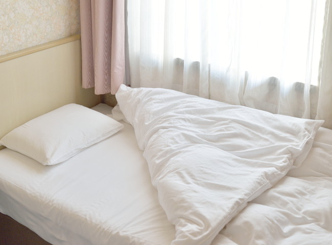 白い寝具で整ったベッド