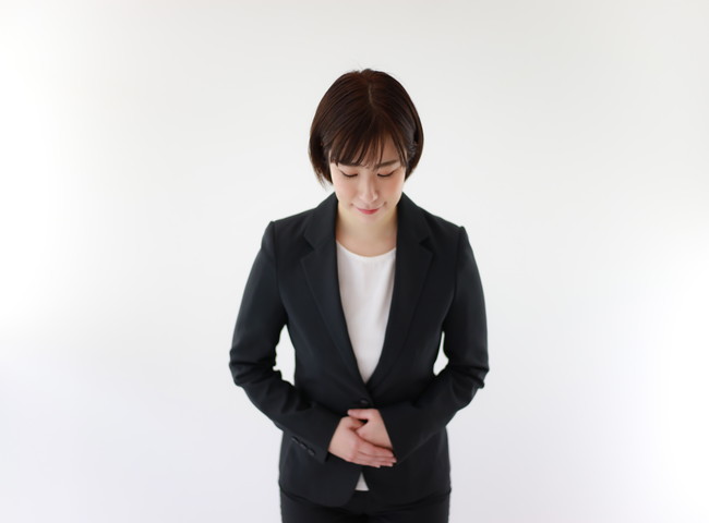 スーツ姿でお辞儀をする女性