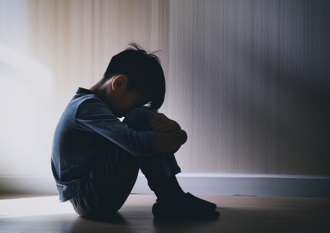 膝を抱える子ども