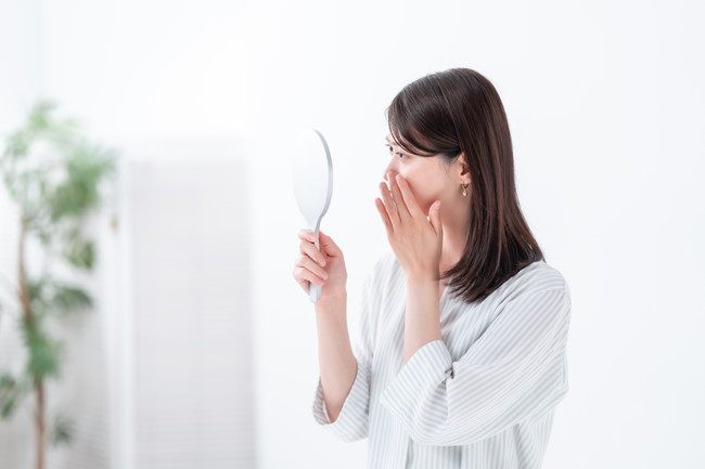 鏡を手に持つ女性