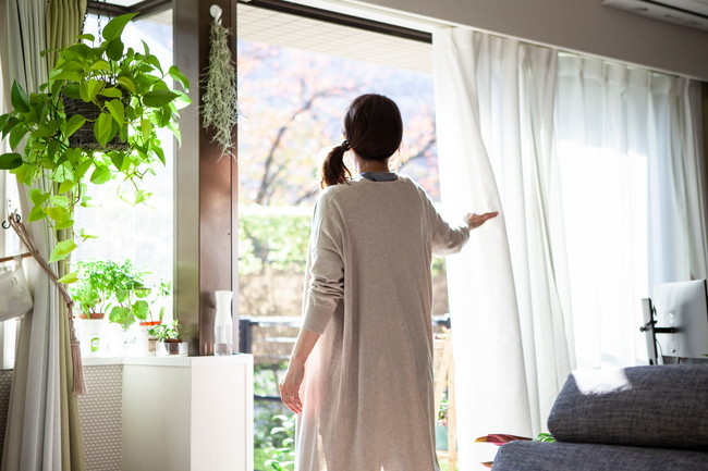 窓を開ける女性