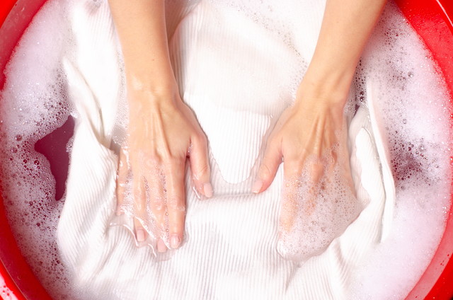 白いセーターの服を洗う女性