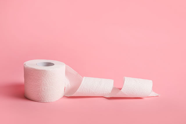 Toilet paper roll on pink background