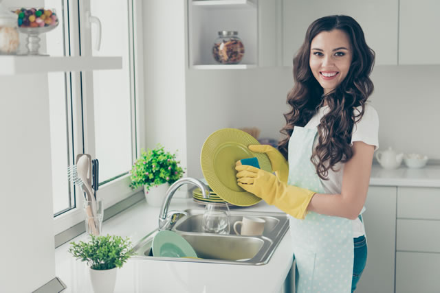 台所で食器を洗う女性